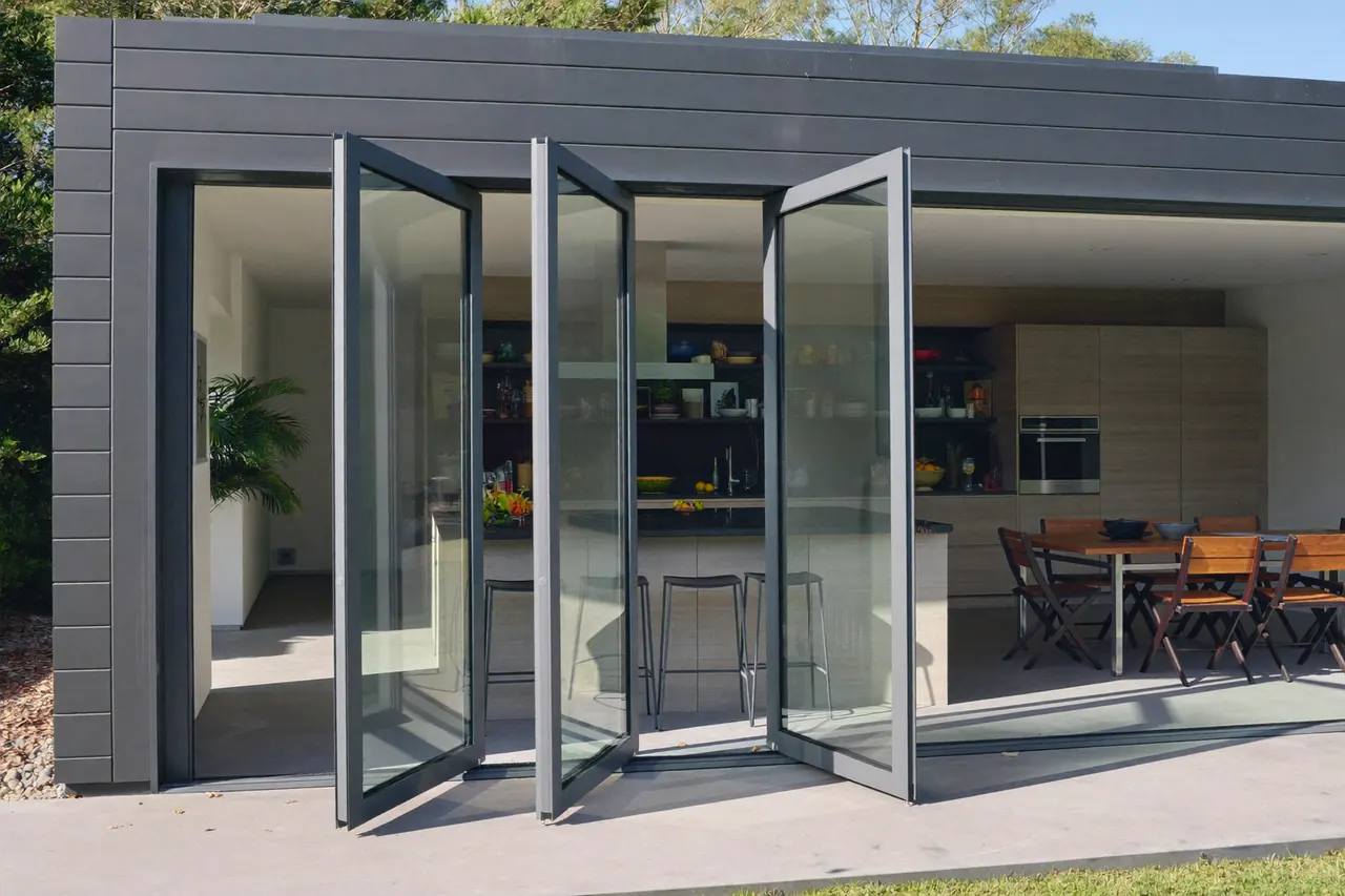 Anthracite aluminium bifold doors folded open across the rear of a kitchen extension