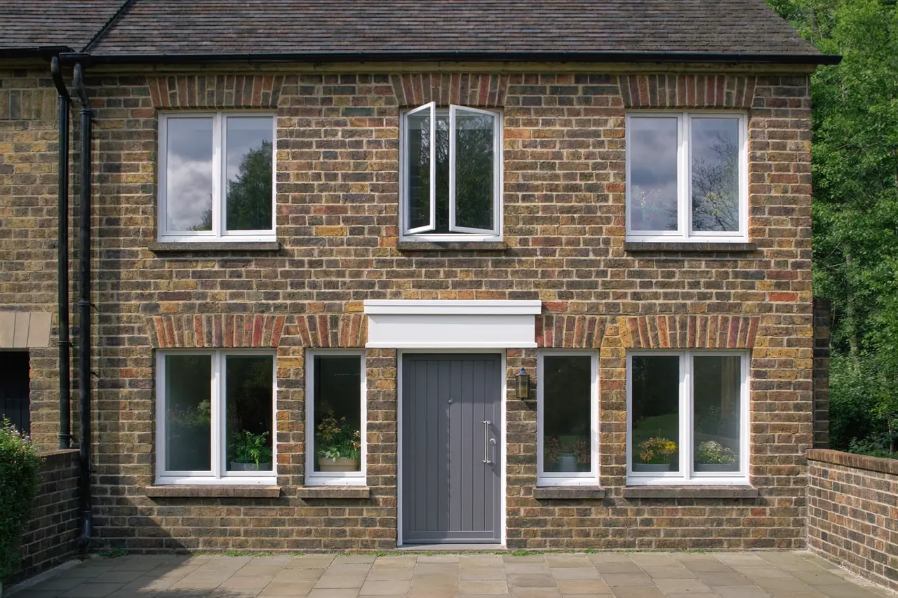 Matching white uPVC windows and a composite front door on a brick terraced house