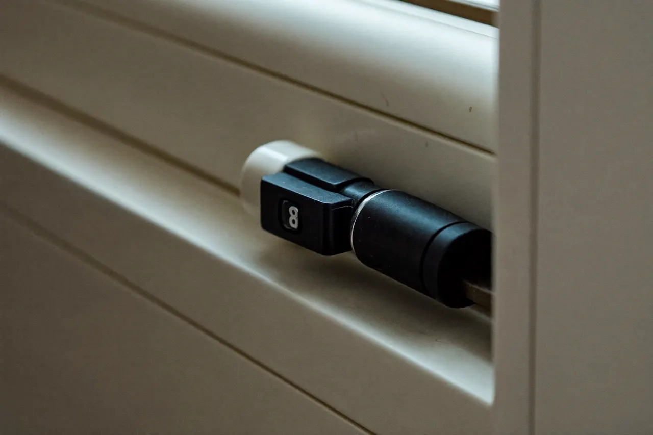 Close-up of a new window hinge and rubber weather seal on a white uPVC casement frame